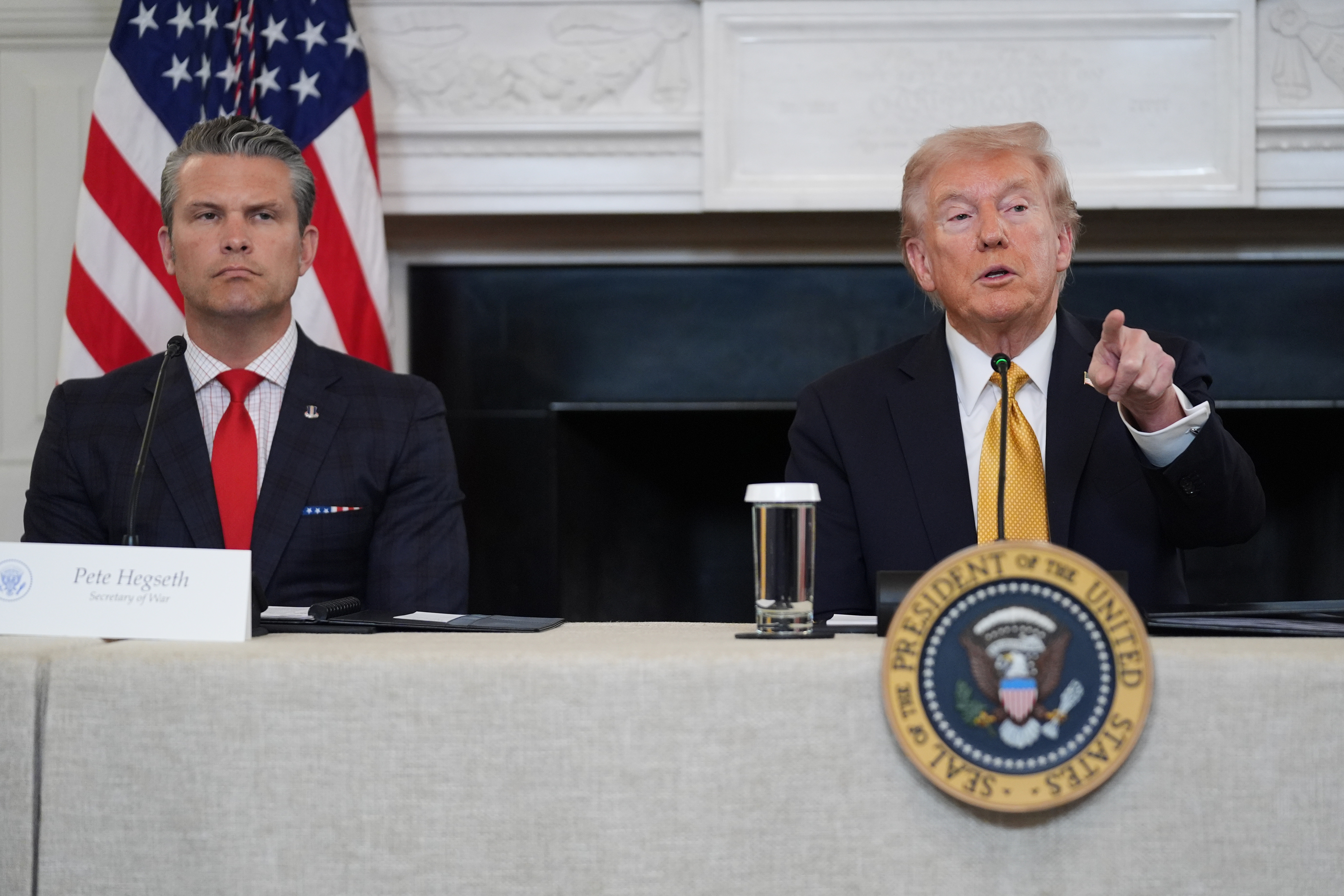 President Donald Trump answers questions from reporters during a roundtable on criminal cartels in the State Dining Room of the White House, Thursday, Oct. 23, 2025, in Washington, as Defense Secretary Pete Hegseth listens.